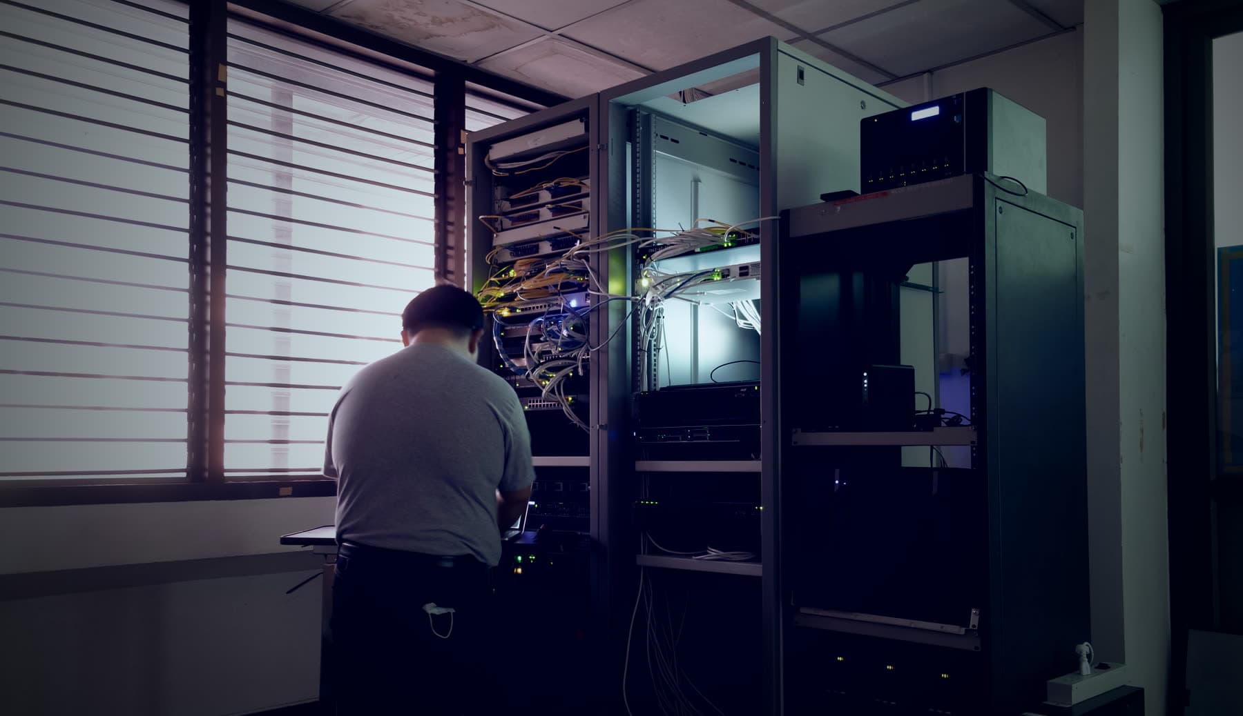 Técnico instalando equipamentos em um rack de TI hospitalar